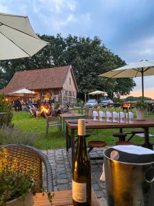 a bottle of wine sitting next to a table with a barrel at Nordenholzer Hofhotel in Hude