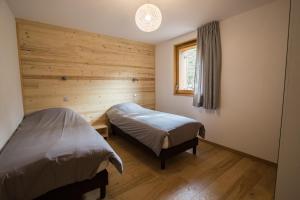 a bedroom with two beds and a window at Les Sabots d'Hélène in Valloire