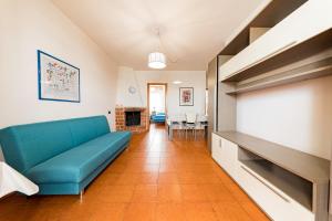 a living room with a blue couch and a dining room at Lily Flat - San Foca in San Foca