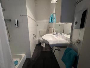 a white bathroom with a sink and a toilet at Hotel Hüttl in Worms +17 photos