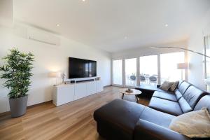 a living room with a blue couch and a flat screen tv at VILLA PAG - SVETA MARIJA in Pag