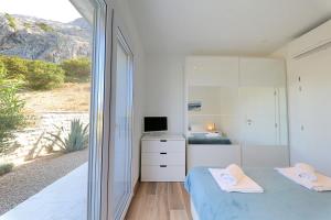 a bedroom with a bed and a tv and a window at VILLA PAG - SVETA MARIJA in Pag +62 photos