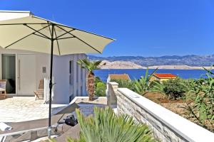 a patio with an umbrella and a view of the water at VILLA PAG - SVETA MARIJA in Pag