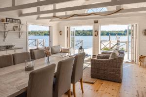 a dining room with a table and chairs and a view of the water at Villa Kolartorp in Ekolsund
