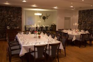 a banquet room with white tables and chairs with candles at Klosterkrug Marienmünster in Marienmünster