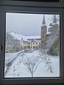 a window view of a building in the snow at Klosterkrug Marienmünster in Marienmünster +24 photos