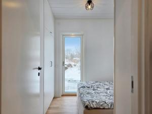 a bedroom with a bed and a door with a window at Nybyggt hus med 3 sovrum, jacuzzi och närhet till strand in Bergkvara
