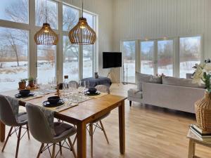 a living room with a table and a couch at Nybyggt hus med 3 sovrum, jacuzzi och närhet till strand in Bergkvara