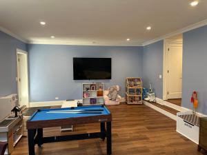 a living room with a ping pong table and a tv at The Lyons' Den in Chicago