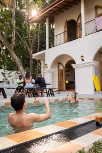 a group of people in the swimming pool of a house at Lucky U Hostel in Ahangama