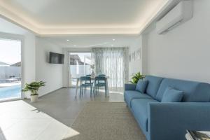 a living room with a blue couch and a table at Villa Nidea in Ragusa