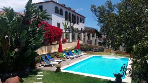 a resort with a swimming pool and chairs and a building at Purple Studio in Funchal