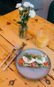 a plate of food with eggs on a wooden table at Story Rooms in Olomouc