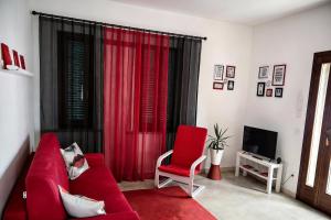 a living room with a red couch and a red chair at Casa Effe in Cecina