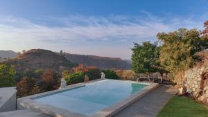 a swimming pool with a mountain in the background at Fateh Safari Resort by Fateh Collection in Kumbhalgarh