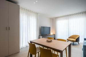 a living room with a table and chairs and a television at A&G Blue flat in Cavallino-Treporti