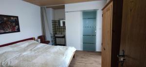a bedroom with a bed and a room with a desk at Ferienwohnung Liebau in Bayerisch Eisenstein