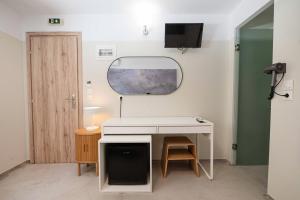 a room with a white desk and a mirror at LUX Hotel 5 mins walk from port of Piraeus and metro station in Piraeus