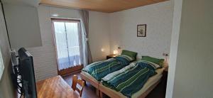 a bedroom with a bed with green pillows and a window at Ferienwohnung Liebau in Bayerisch Eisenstein