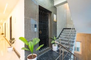 a hallway with potted plants and a staircase at Itsy Hotels Saffron Groves in Hyderabad
