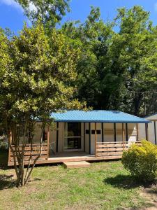 a small house with a blue roof and a tree at Camping Turismar in Tossa de Mar