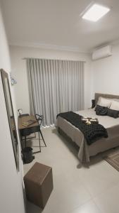 a bedroom with a bed and a desk in it at Jahu Center Casas Un 8 in Jaú