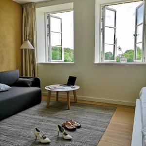a living room with a couch and a table with a laptop at Nordenholzer Hofhotel in Hude