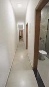 a hallway with a bathroom with a toilet and a shower at Jahu Center Casas Un 8 in Jaú +74 photos