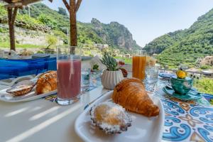 a table topped with plates of pastries and drinks at Villa Zagara in Amalfi