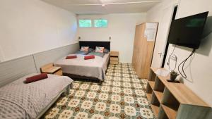 a room with two beds and a flat screen tv at Gesztenyés Üdülő in Balatonudvari