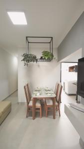 a dining room with a table and chairs and a television at Jahu Center Casas Un 8 in Jaú