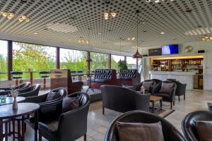 a restaurant with chairs and tables and a bar at Sunday Hotel des Nordens in Flensburg