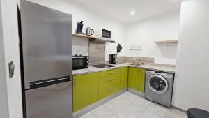 a kitchen with a refrigerator and a washing machine at Le Petit Minck in Grand-Fort-Philippe