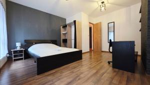 a bedroom with a large bed and a wooden floor at Le Petit Minck in Grand-Fort-Philippe