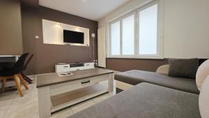 a living room with a couch and a tv at Le Petit Minck in Grand-Fort-Philippe