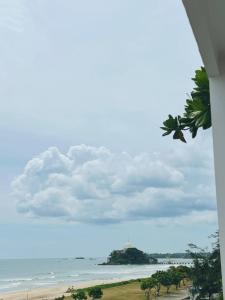 a view of the beach and the ocean from a window at REEF VIEW Beach Hotel in Matara