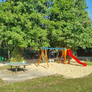 a playground with a slide and a bench at Gesztenyés Üdülő in Balatonudvari