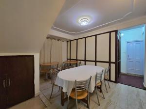a dining room with a white table and chairs at Newlands homestay near mall in Shimla