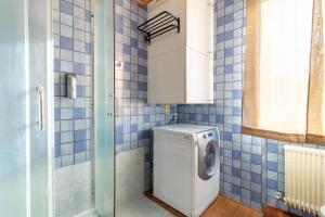 a washing machine in a bathroom with blue tiles at Ca Correr 326 in Cittadella