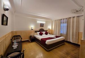 a hotel room with a bed and a table and a bed and a table at Newlands homestay near mall in Shimla