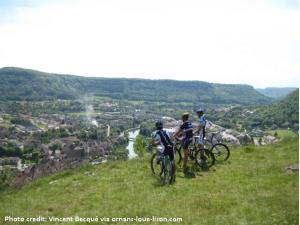three people riding bikes on a hill overlooking a river at Le Refuge des Loups Blancs 12 pers in Ouhans