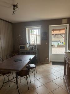 a dining room with a wooden table and chairs at Maison d’izier in Izier