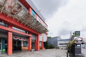 a large building with red columns at Urbanview Hotel Niraz Banjarmasin by RedDoorz in Sungai Lutus