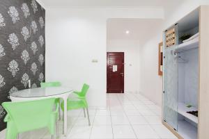 a dining room with a table and green chairs at Urbanview Hotel Niraz Banjarmasin by RedDoorz in Sungai Lutus