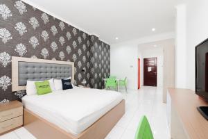 a bedroom with a large bed and a tv at Urbanview Hotel Niraz Banjarmasin by RedDoorz in Sungai Lutus