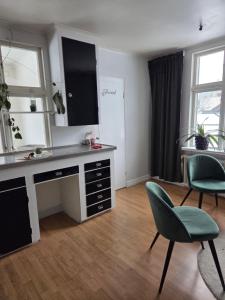 a kitchen with a desk and two chairs in a room at Blomstermåla in Blomstermåla