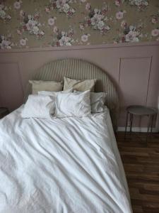 a bed with white sheets and pillows in a bedroom at Blomstermåla in Blomstermåla