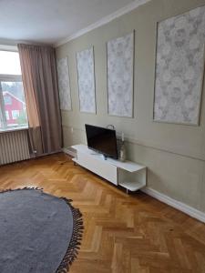 a living room with a table and a laptop on the wall at Blomstermåla in Blomstermåla