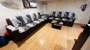 a living room with two leather couches and a table at Jai Krishna Guest House in Ayodhya