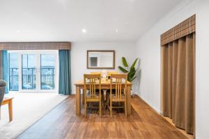 a dining room with a wooden table and chairs at Stag & Stay- Waterlillie - Contractor friendly, Fast WiFi in Port Glasgow